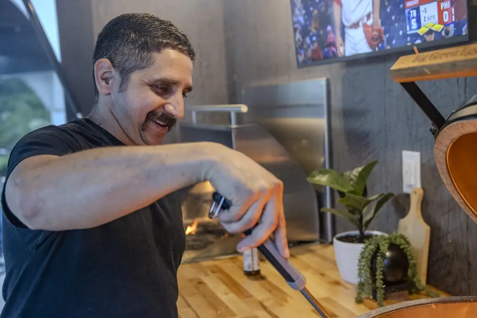 Dave King smiling while lighting the grill in a Flamehouse