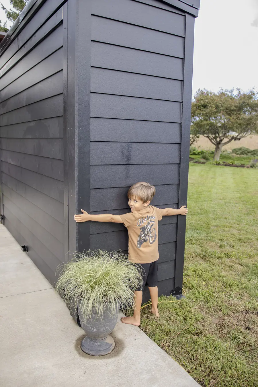 A young boy stretching his arms across the side of a Flamehouse to show how it stands