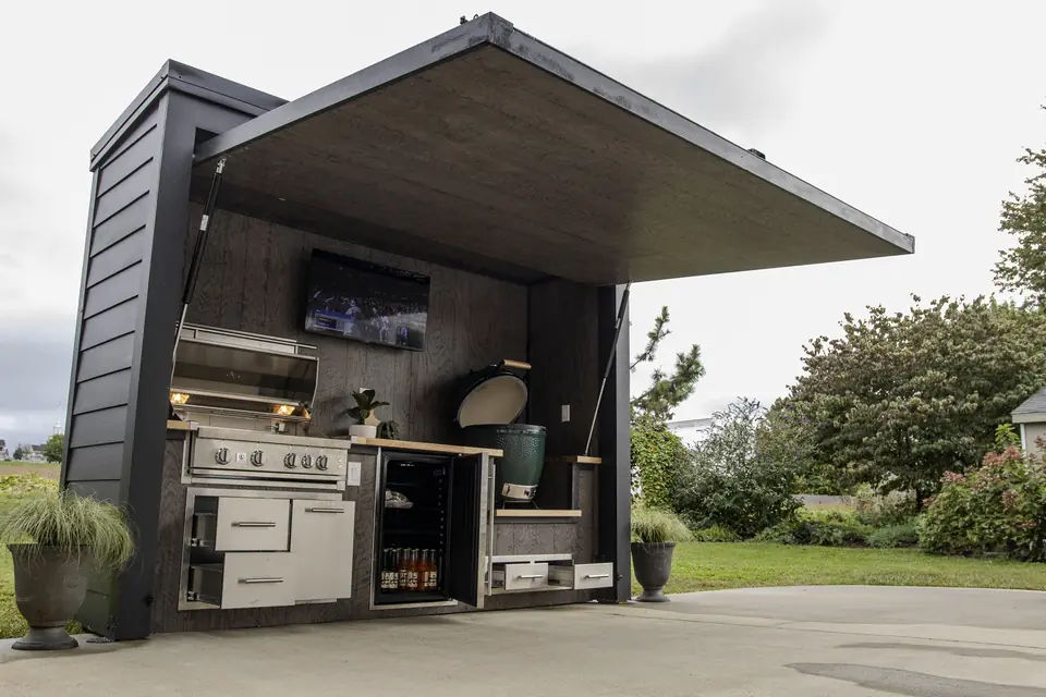 A Flamehouse with its doors open: grill, ceramic egg, fridge and storage ready to go