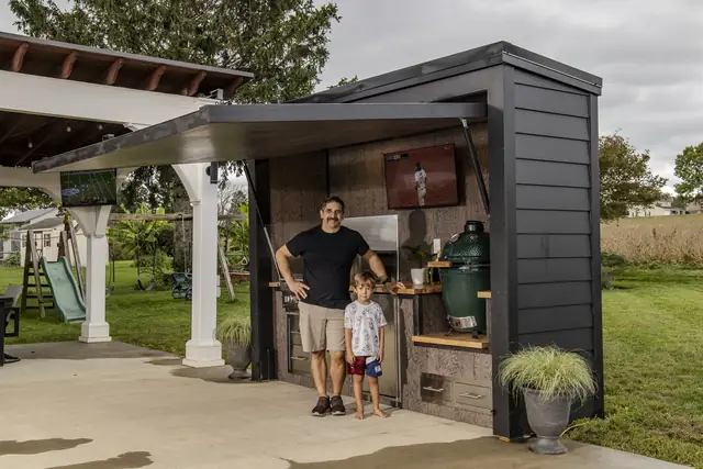 A dad and his son standing at their open Flamehouse