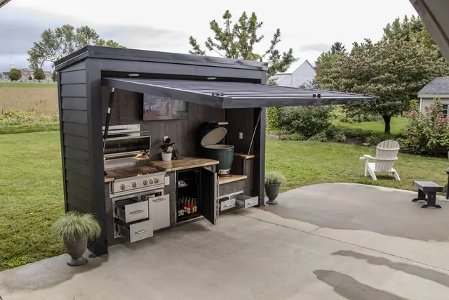 A Flamehouse with its doors open: grill, fridge, ceramic egg, and storage drawers